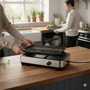 A person removing dishwasher-safe non-stick plates from an indoor electric grill for easy cleaning after a meal.