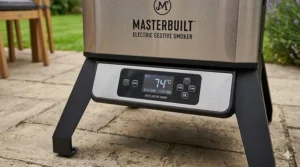 A close-up of a digital control panel on an electric smoker showing a precise temperature setting of 74 degrees Celsius.