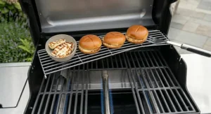 An internal chrome-plated warming rack above the main grill area of a 3 burner gas BBQ to keep food hot.