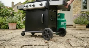 Side view of a 3 burner gas BBQ showing heavy-duty wheels and casters for easy movement across a garden lawn or patio.