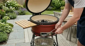 Using an ash tool to remove cooled charcoal remains from the base of a ceramic grill.