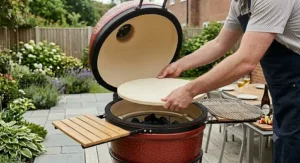 Placing a ceramic heat deflector stone inside the kamado barbecue for indirect cooking.