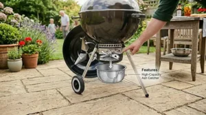Close-up of the sturdy wheels and handle on a budget kettle BBQ for easy movement.