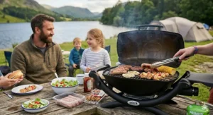 A person placing the folded portable gas BBQ into a tailored black carry bag next to a picnic table, ready for packing after a camping trip.