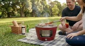 A couple enjoying a summer barbecue picnic in the countryside with a portable grill.