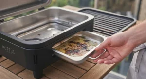Showing the removable grease tray of an outdoor electric BBQ for easy cleaning.