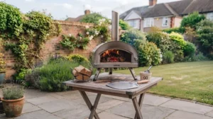 A small, economical wood-fired pizza oven sitting neatly on a compact patio table.