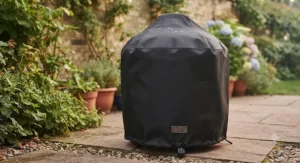 A weatherproof cover protecting a small barbecue, essential for UK weather, included in a set under £200.