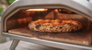 A compact outdoor electric pizza oven placed safely on a small urban flat balcony table.