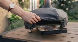 Freshly baked artisanal pizza with a charred crust being sliced on a wooden board.