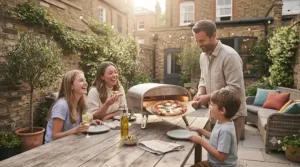 Family enjoying homemade artisan pizzas cooked in a portable electric pizza oven outdoors