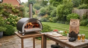 A complete garden patio setup featuring a wood-fired pizza oven fueled by hardwood lumpwood charcoal.
