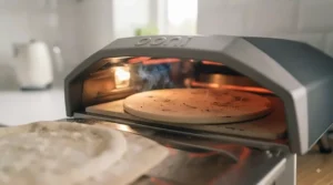 Close-up of a cordierite baking stone inside a hot electric pizza oven cooking a crispy pizza crust.