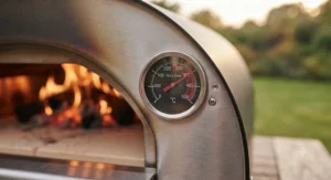 Built-in thermometer on a garden pizza oven reaching high temperatures using hardwood lumpwood charcoal.