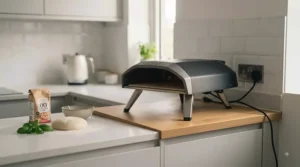 A portable countertop electric pizza oven fitting easily on a small apartment kitchen worktop.