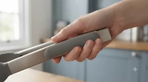 Chef holding comfortable silicone tipped tongs featuring a soft-grip handle for better control.
