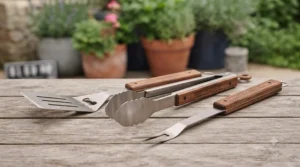 Essential utensils included in a standard BBQ tool set featuring heavy-duty tongs, a slotted spatula, and a grilling fork.