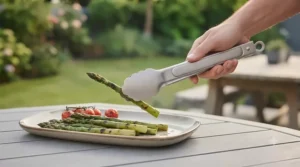 Scalloped gripped edge on long handle BBQ tongs securely turning gourmet burgers on a hot grill.