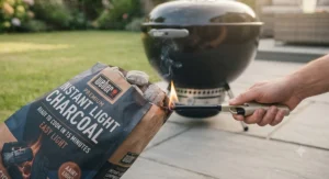 Close-up of instant light charcoal safely catching fire with a single match for a hassle-free barbecue.