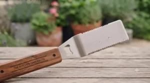 A multi-functional spatula from a BBQ tool set featuring a serrated edge and an integrated bottle opener for outdoor drinks.