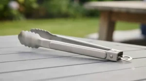 Close-up of heavy-duty stainless steel build on long handle barbecue tongs for rust resistance.